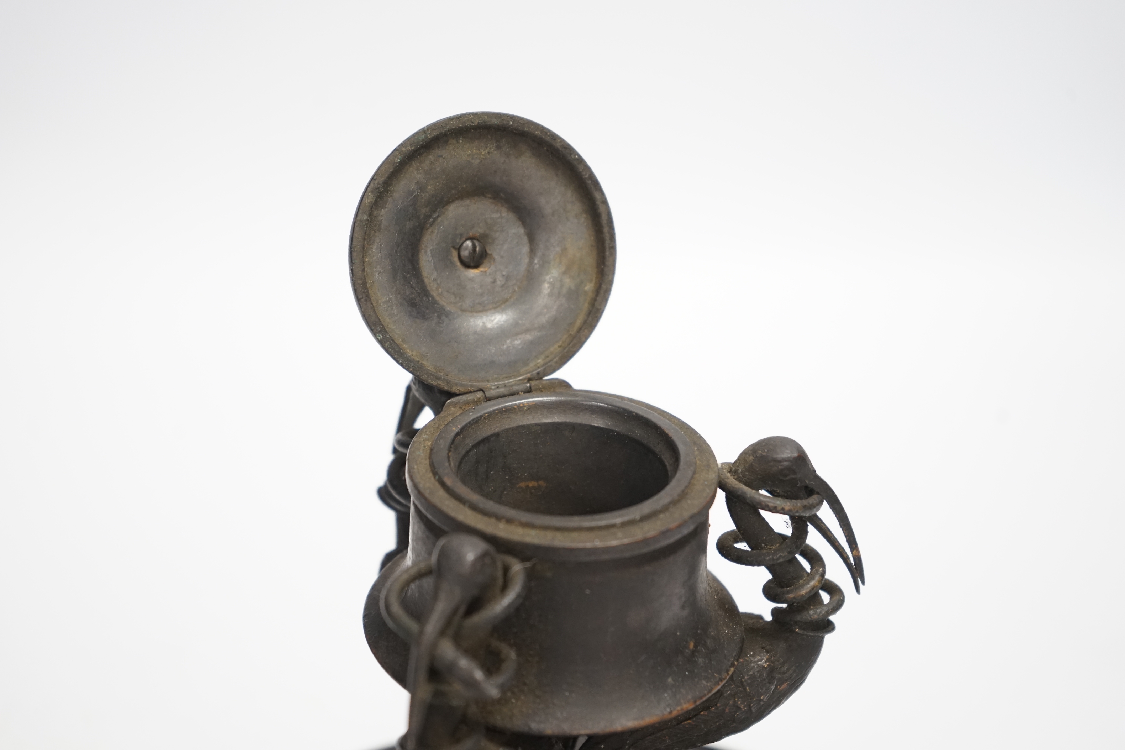 A late 19th century patinated metal inkwell, modelled with three cranes on an ebonised pine base, 18cm